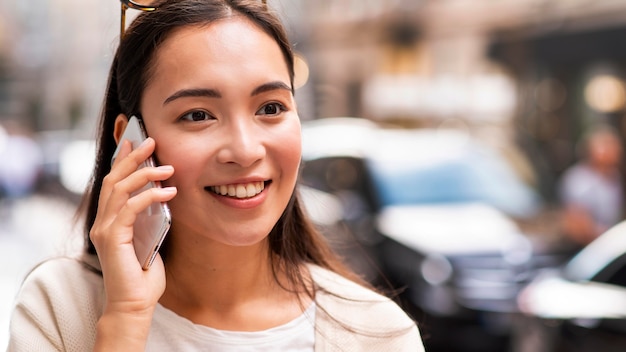 Donna di smiley che parla sullo smartphone all'aperto