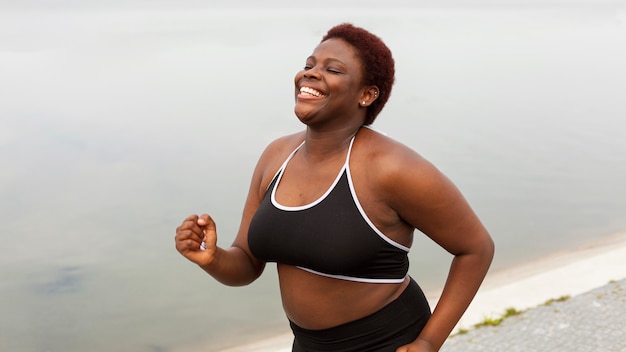 Donna di smiley che salta sulla spiaggia