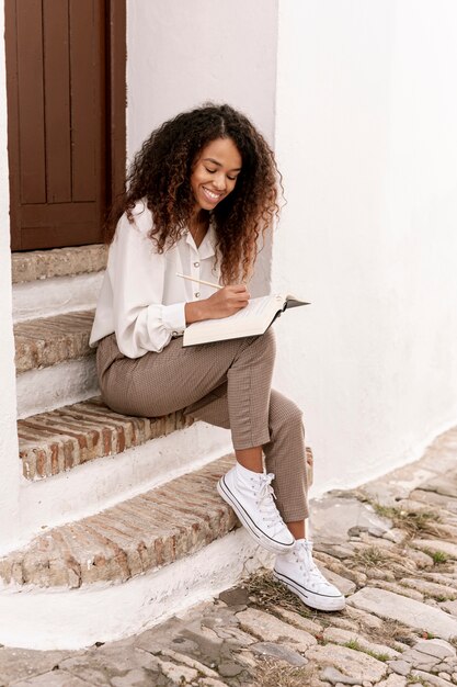 Donna di smiley che tiene un libro aperto
