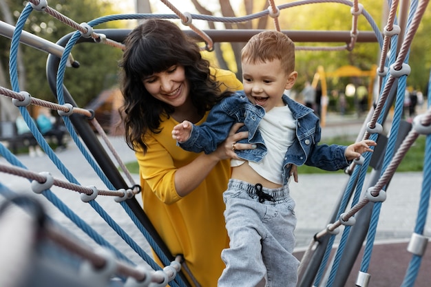 Donna di smiley colpo medio che tiene bambino