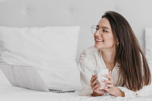 Donna di smiley colpo medio con il computer portatile