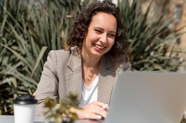 Donna di smiley colpo medio con il computer portatile