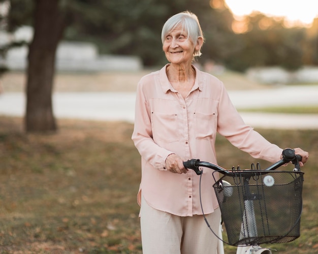 Donna di smiley colpo medio con la bicicletta