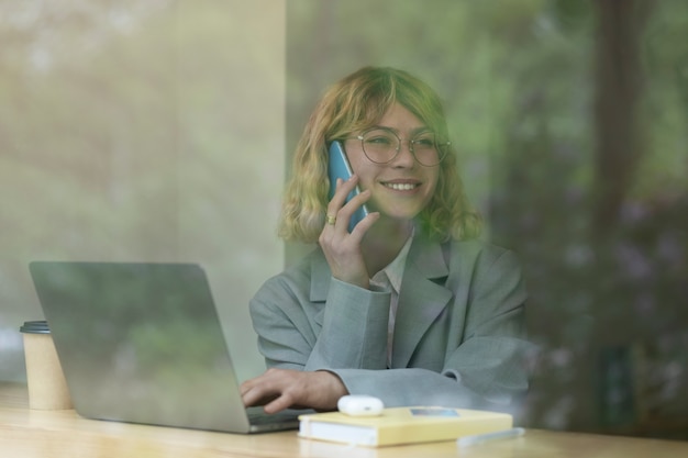 Donna di smiley del colpo medio che parla sul telefono