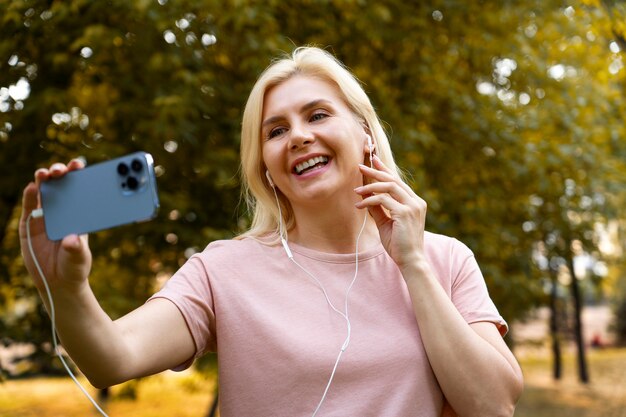 Donna di smiley del colpo medio che prende selfie