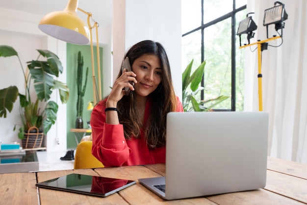 Donna di smiley del colpo medio con il computer portatile