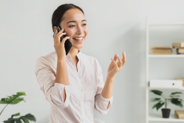 Donna di smiley del ritratto che parla sopra il telefono