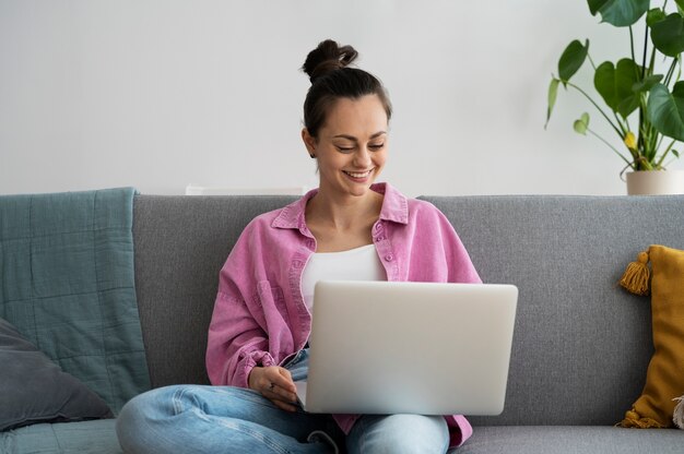 Donna di smiley di vista frontale che lavora al computer portatile