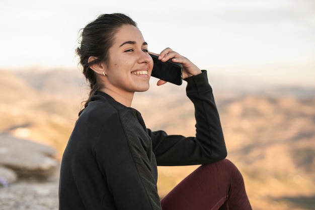 Donna di smiley di vista frontale che parla sopra il telefono