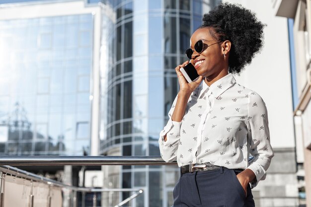 Donna di smiley di vista laterale che parla sopra il telefono