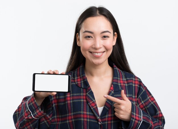 Donna di smiley in pigiama che indica al telefono