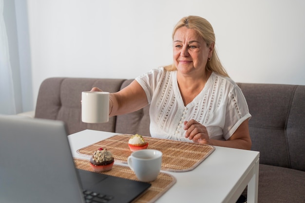 Donna di smiley in quarantena un caffè con gli amici sul computer portatile