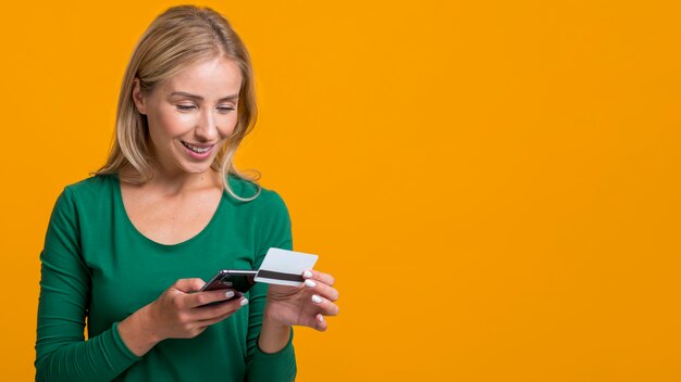 Donna di smiley riempiendo le informazioni della sua carta di credito sullo smartphone