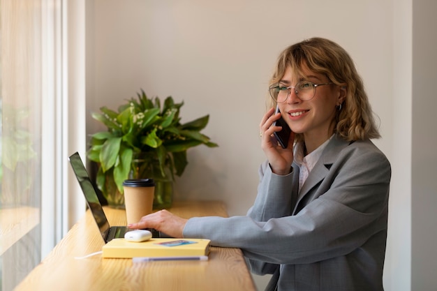 Donna di smiley vista laterale che parla sul telefono