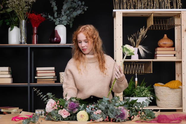 Donna di taglio medio che lavora in un negozio di fiori.