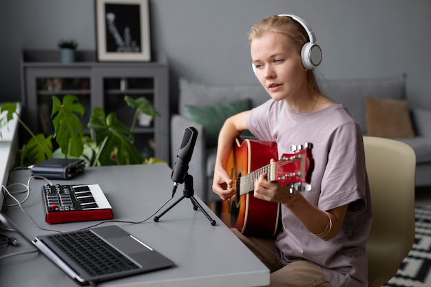 Donna di tiro medio che fa musica a casa