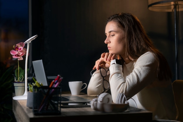 Donna di tiro medio che lavora a tarda notte