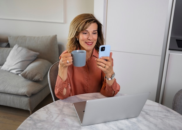 Donna di tiro medio che si prende una pausa con lo smartphone