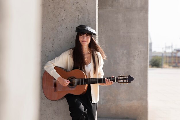 Donna di tiro medio che suona la chitarra