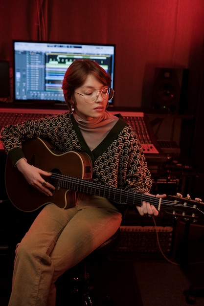 Donna di tiro medio che suona la chitarra