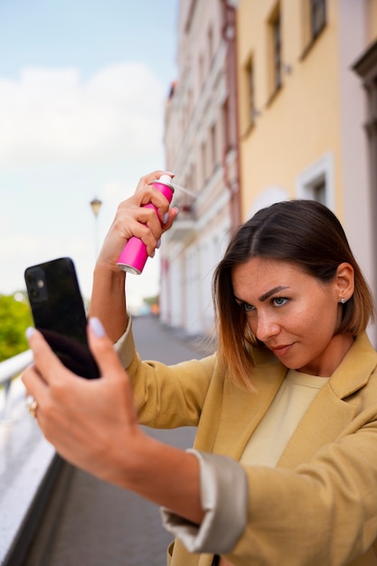 Donna di tiro medio che usa shampoo a secco all'aperto