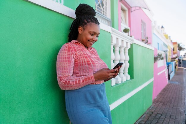 Donna di tiro medio che utilizza smartphone all'aperto