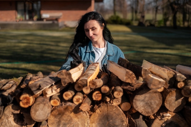 Donna di tiro medio con legno all'aperto