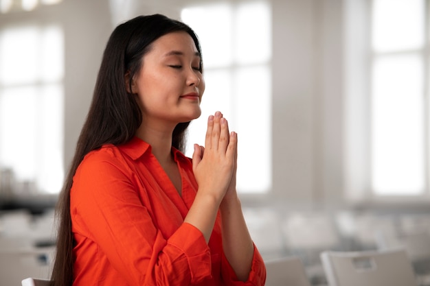 Donna di tiro medio in chiesa a pregare