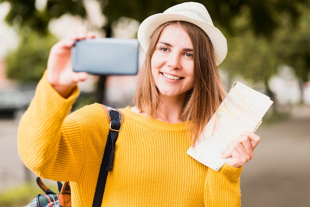 Donna di viaggio di smiley che prende un selfie