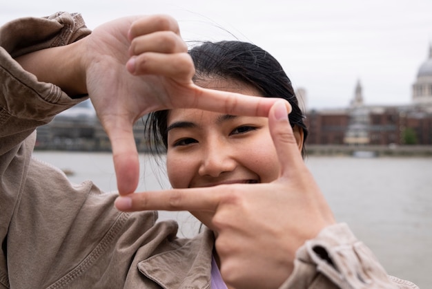 Donna di vista frontale che fa la forma della macchina fotografica