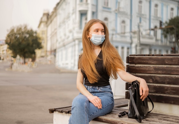 Donna di vista frontale che indossa una mascherina medica all'esterno