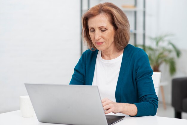 Donna di vista frontale che lavora ad un computer portatile