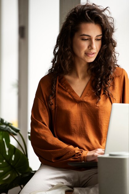 Donna di vista frontale che lavora al computer portatile