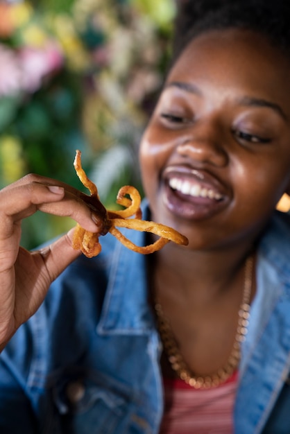 Donna di vista frontale che mangia in un modo divertente