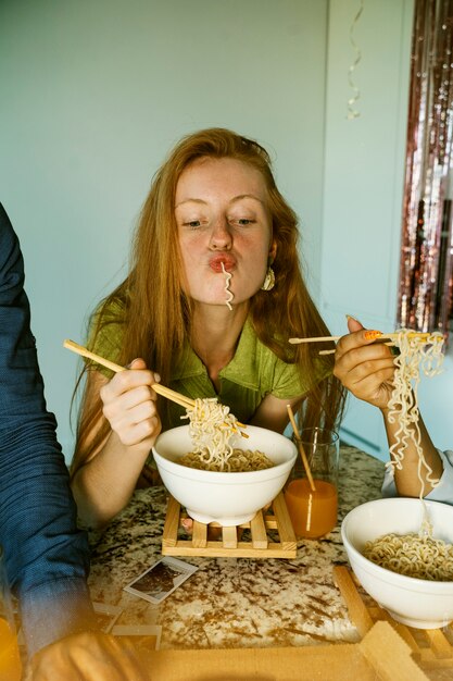 Donna di vista frontale che mangia le tagliatelle