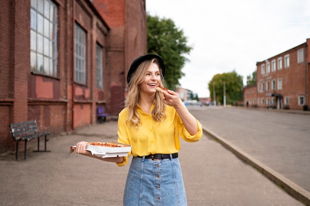 Donna di vista frontale che mangia pizza