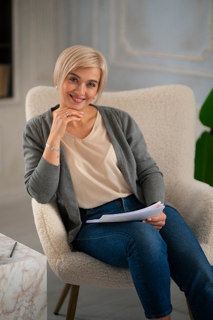 Donna di vista frontale che posa sulla sedia
