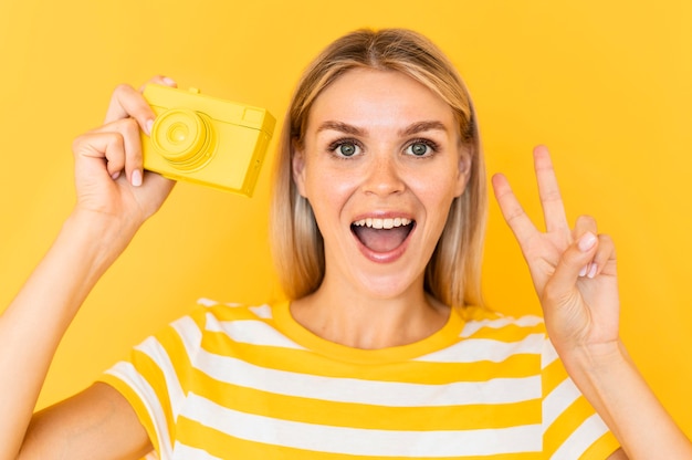 Donna di vista frontale che propone con la macchina fotografica