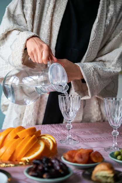 Donna di vista frontale che versa acqua