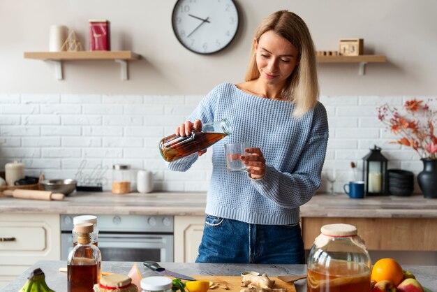 Donna di vista frontale che versa kombucha