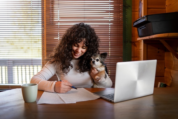 Donna di vista frontale con il computer portatile a casa