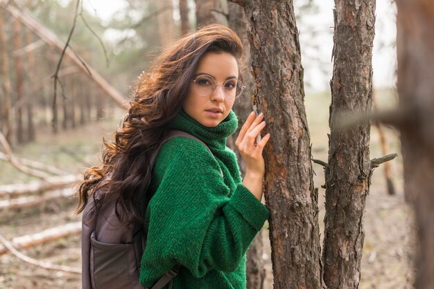 Donna di vista laterale al lato degli alberi