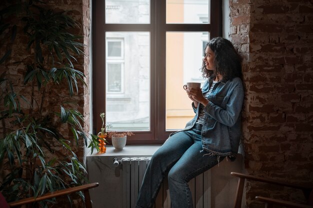 Donna di vista laterale che beve caffè