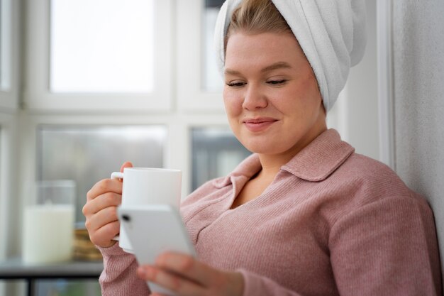 Donna di vista laterale che esamina smartphone