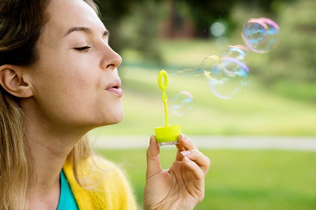 Donna di vista laterale che fa le bolle