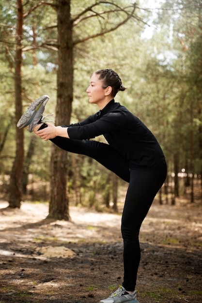 Donna di vista laterale che fa sport all'aperto