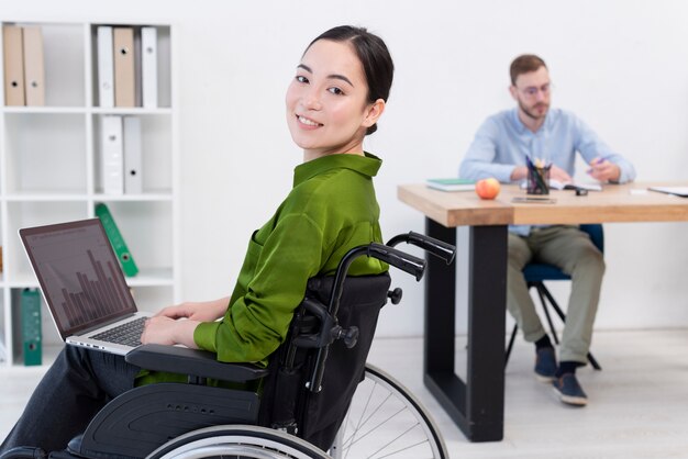 Donna di vista laterale che lavora al computer portatile