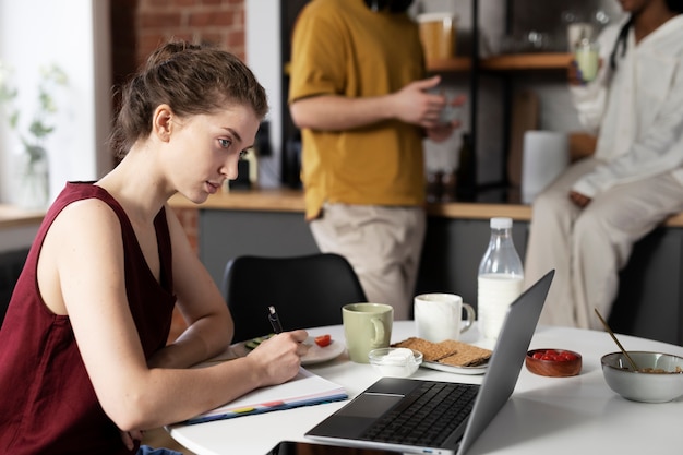 Donna di vista laterale che lavora al computer portatile