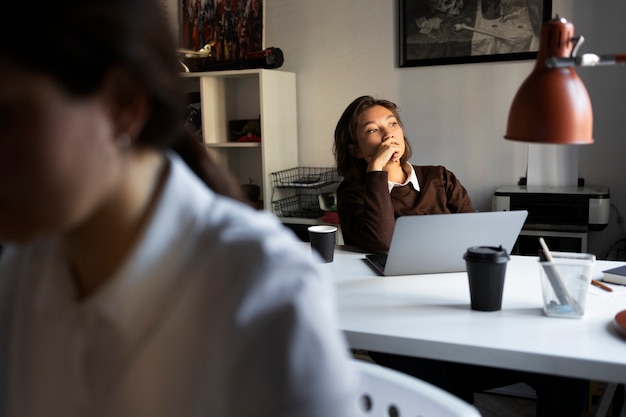 Donna di vista laterale che lavora al computer portatile