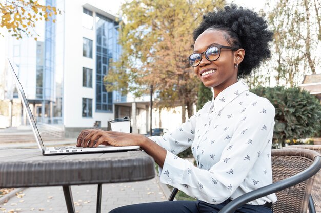 Donna di vista laterale che lavora al dispositivo elettronico